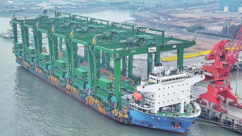 工作人员将国产自动轨道式龙门起重机装载上船